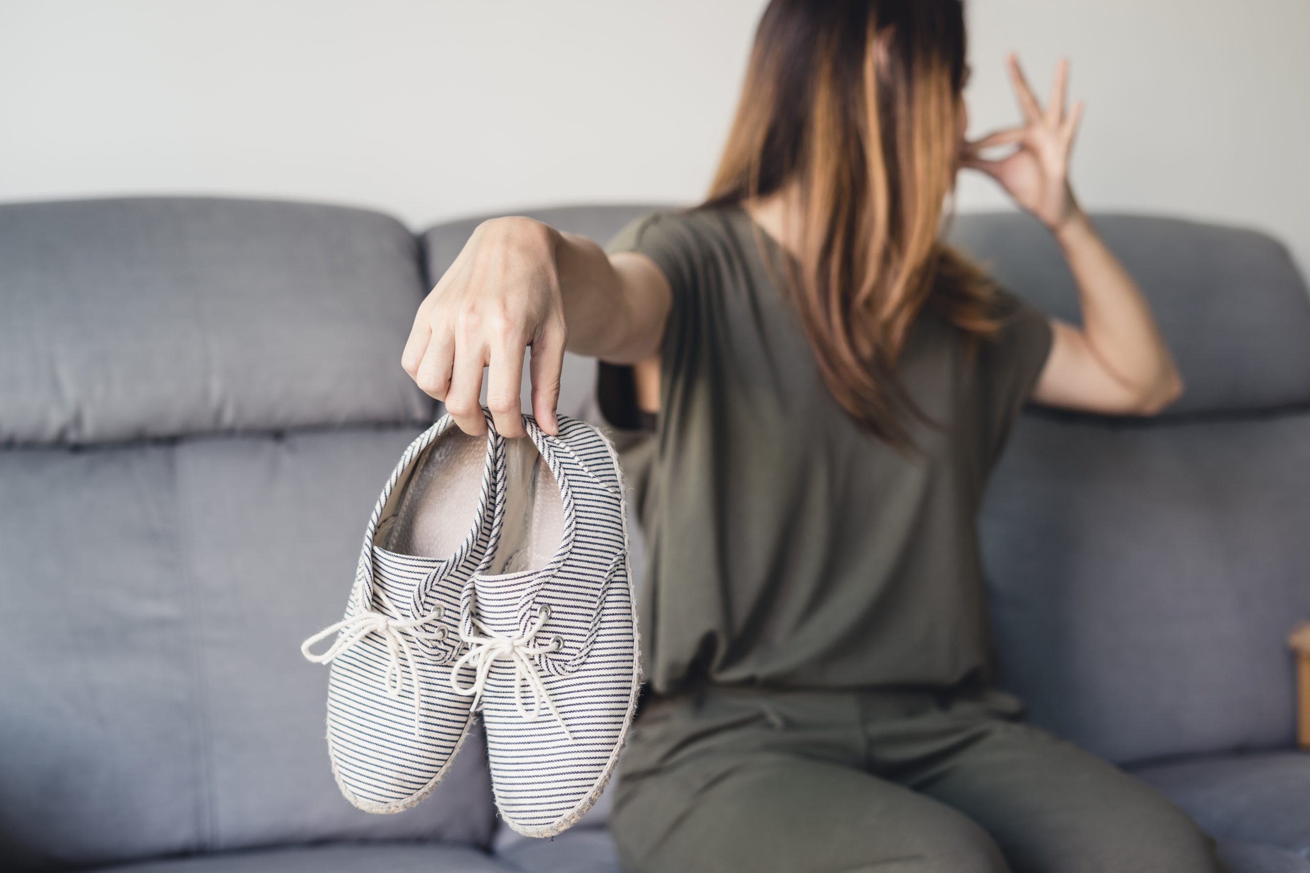 Femme sentant l'odeur baskets